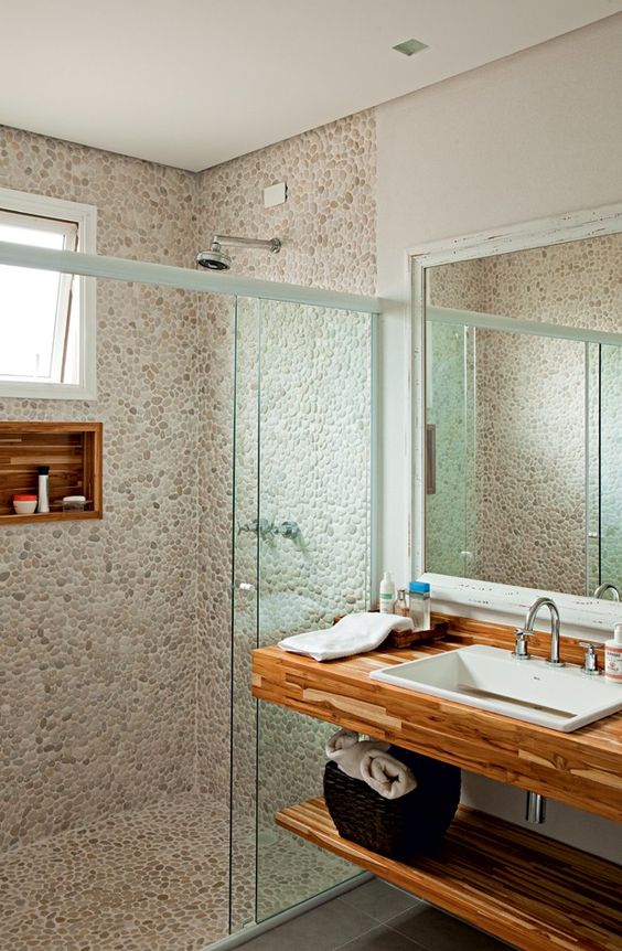 Bathroom with pebbles on the floor and wall.