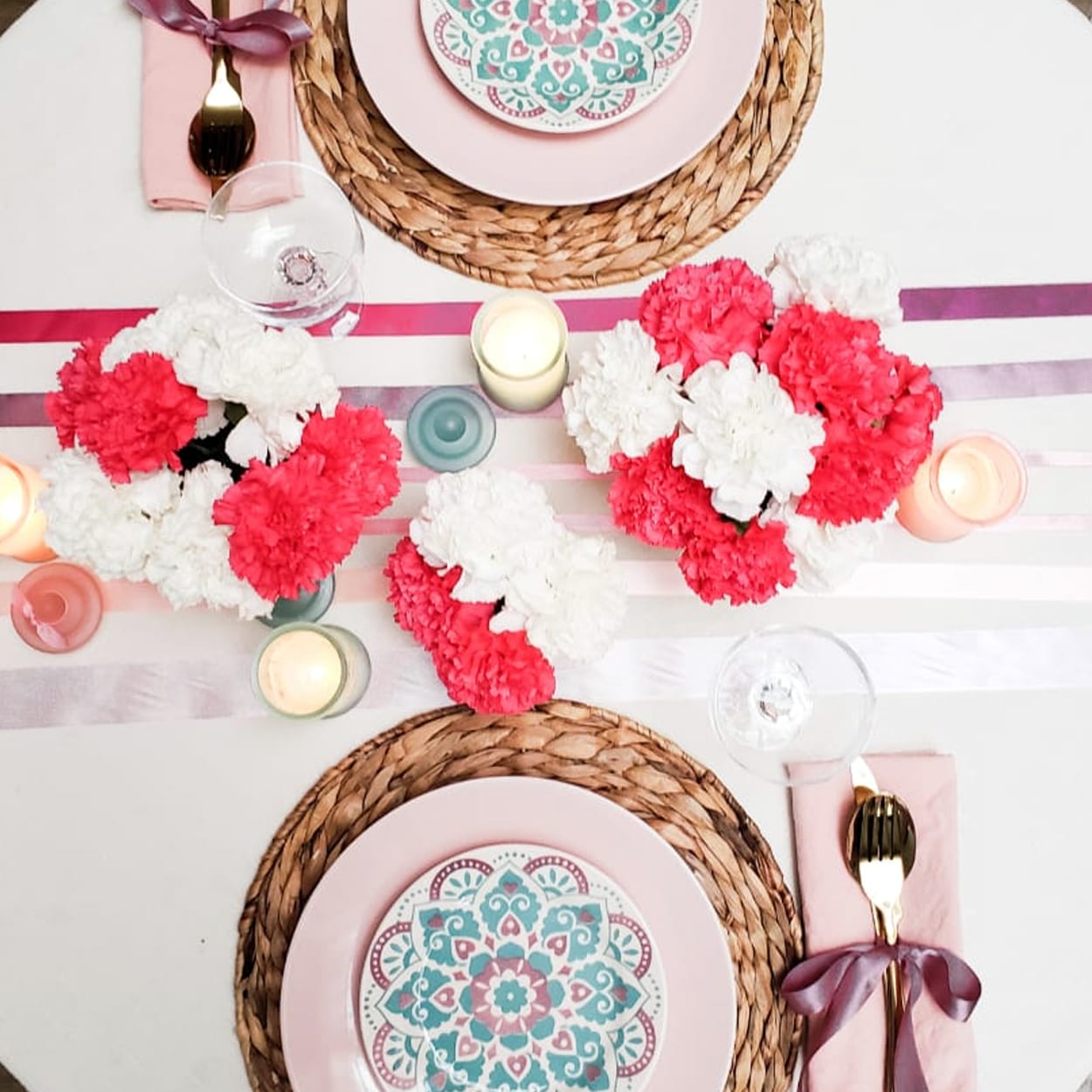 Photo of a table set for a romantic dinner decorated with red and white flowers