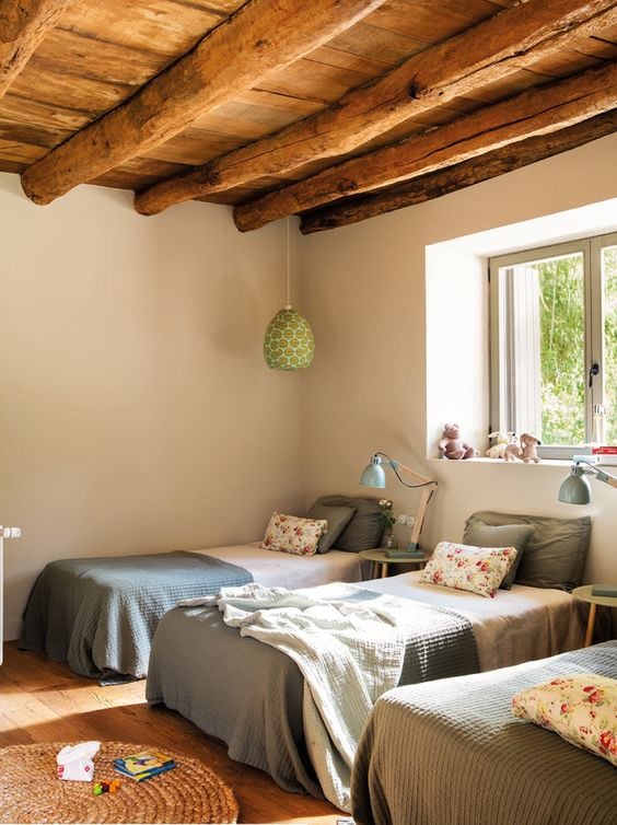 Room with three beds and wooden ceiling