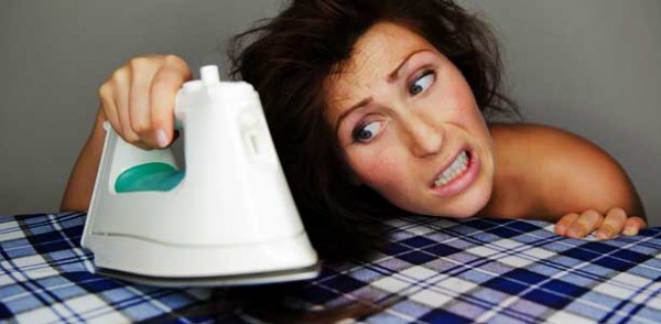 Woman straightening her hair with an iron