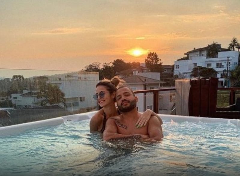 In the photo, Projota and his wife appear in a swimming pool