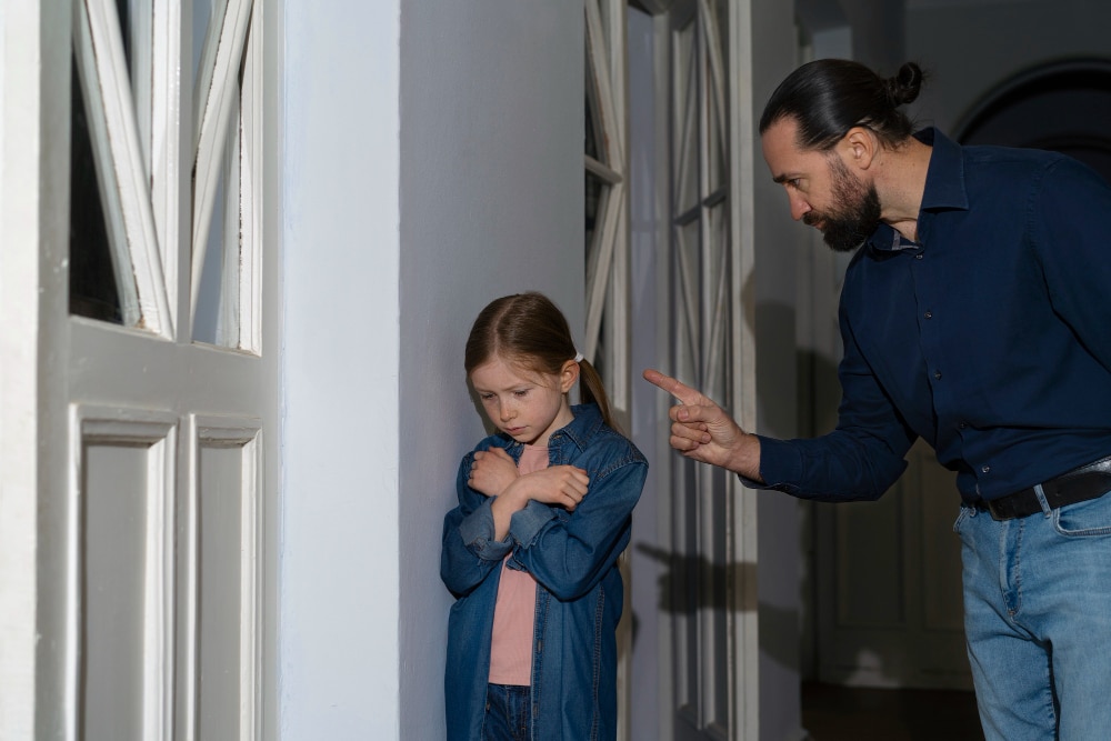 Pai narcisista apontando o dedo e intimidando filha criança