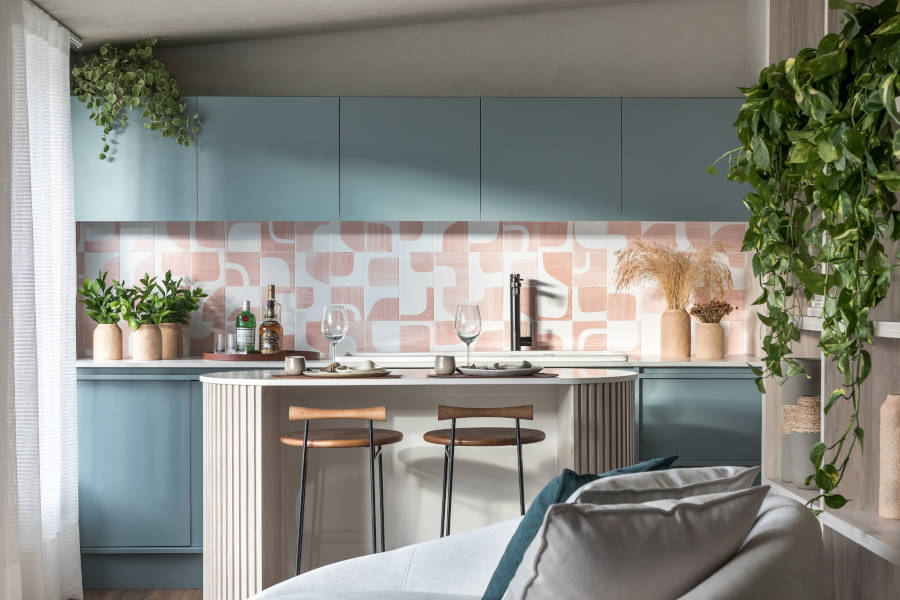 American kitchen with blue cabinets and white and pink tile wall.