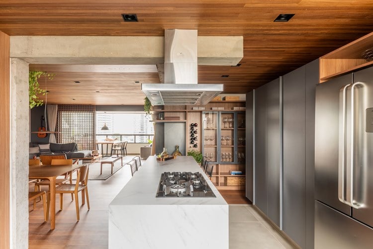 187 m² apartment kitchen decorated by architect Pietro Terlizzi, with marble island with cooktop and hood on top, stainless steel appliances, china cabinet