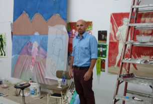 Artista Peter Doig em seu ateliê com quadros na parede