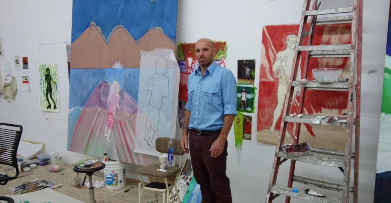 L'artista Peter Doig nel suo studio con dipinti alle pareti