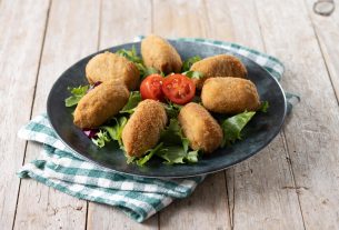 Prato servindo bolinho de bacalhau com salada como opção para o almoço de Páscoa