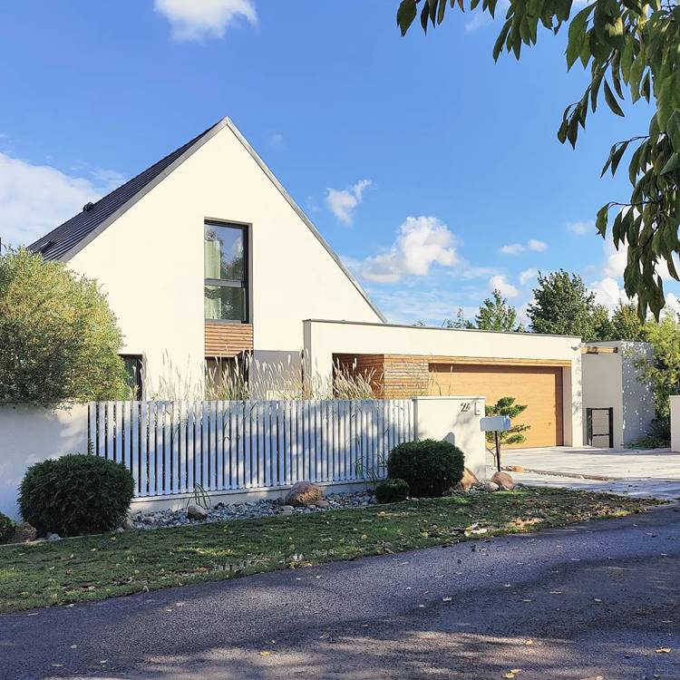 Low wall with chalet-shaped house.  fenced wall