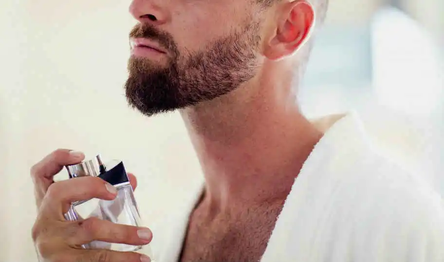 man applying perfume