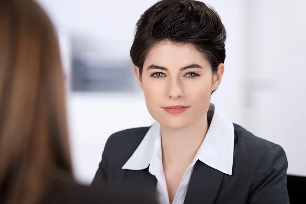 A photo of a woman with short hair in the workplace