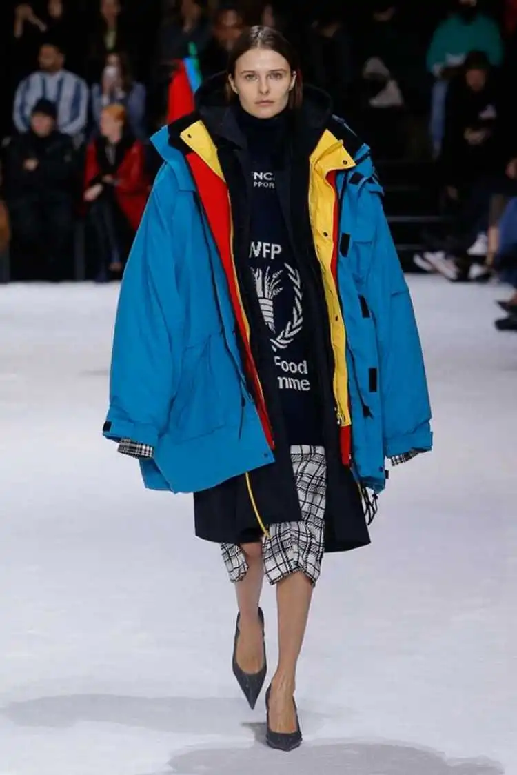 Modelo desfilando com peças sobrepostas para divulgar as tendências da moda inverno 2019.