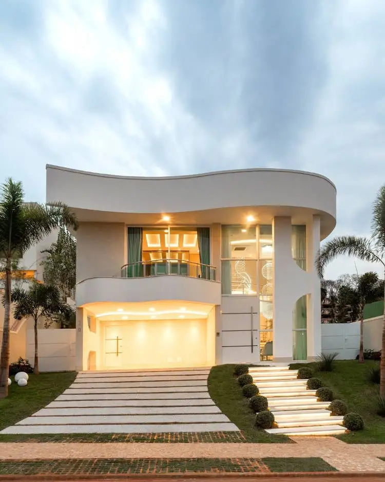 The façade lit up in white, with a balcony.