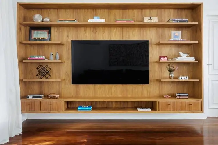 Shelves in wood, with tv, books, table, and other decorative items. 