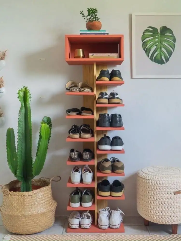 Style de la chaussure de / human centipede dans un peu terre à terre avec plusieurs chaussures. En intégrant le décor, il y a un gros pot avec un cactus, une table de la côte d'adam, et un repose-pieds en beige.