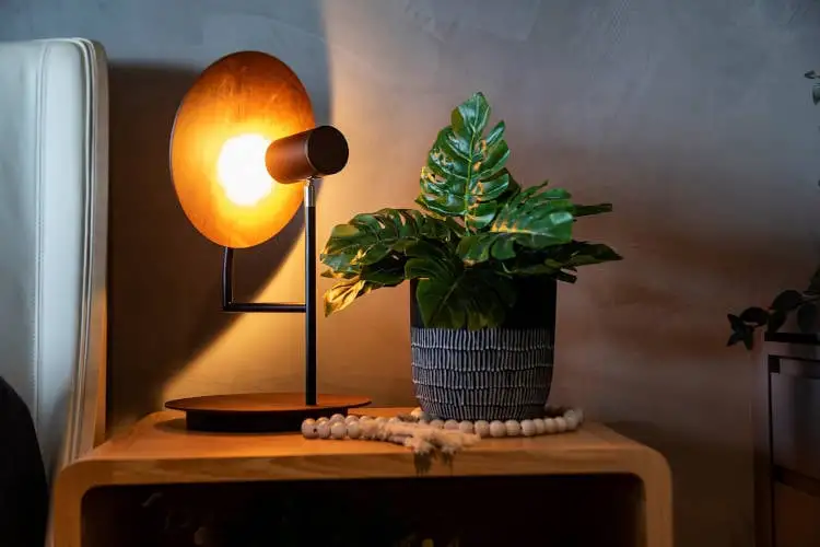 Nachttisch mit moderner Lampe.
